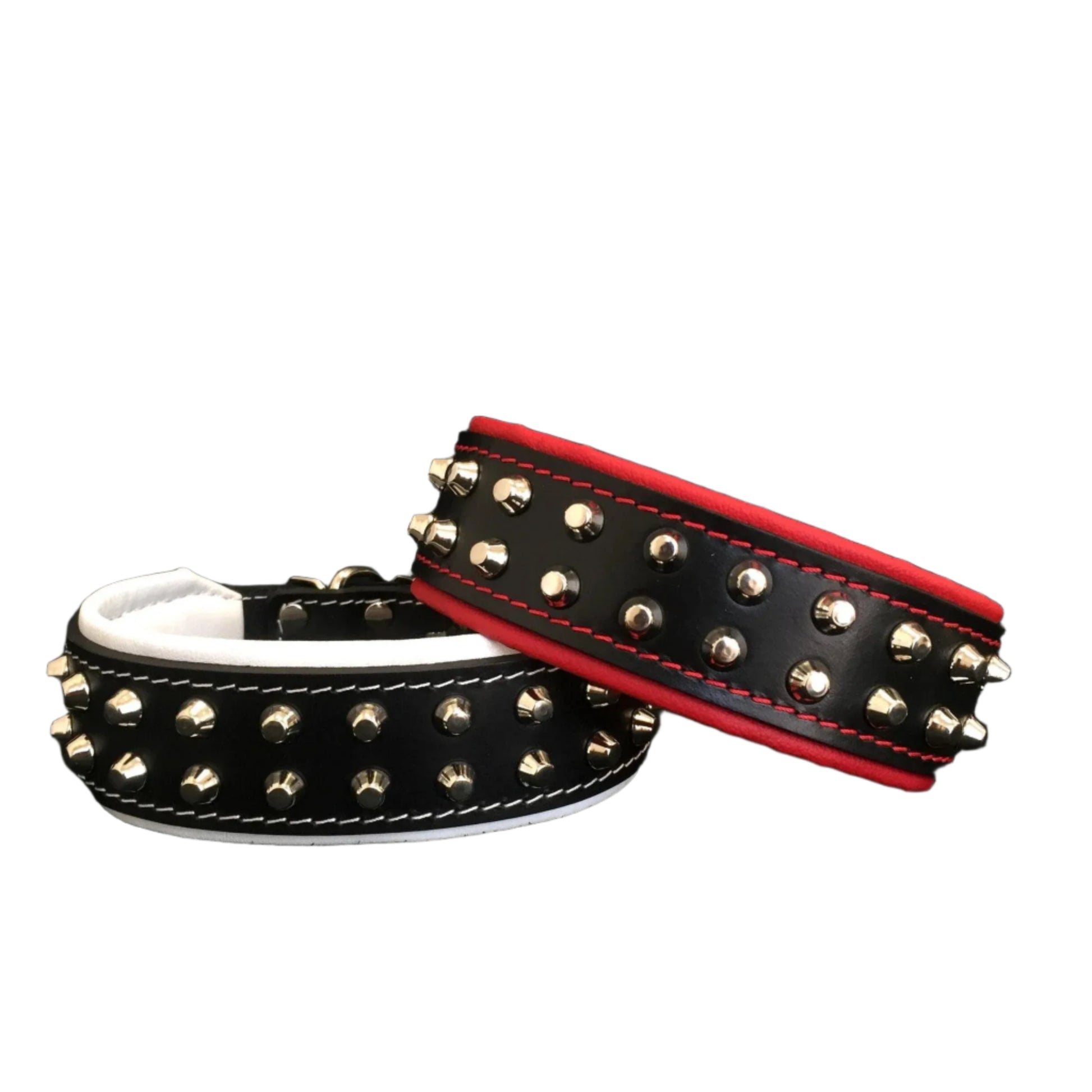 Two studded dog collars, one black with gold studs and white interior, the other black with red interior and gold studs, on a black background.