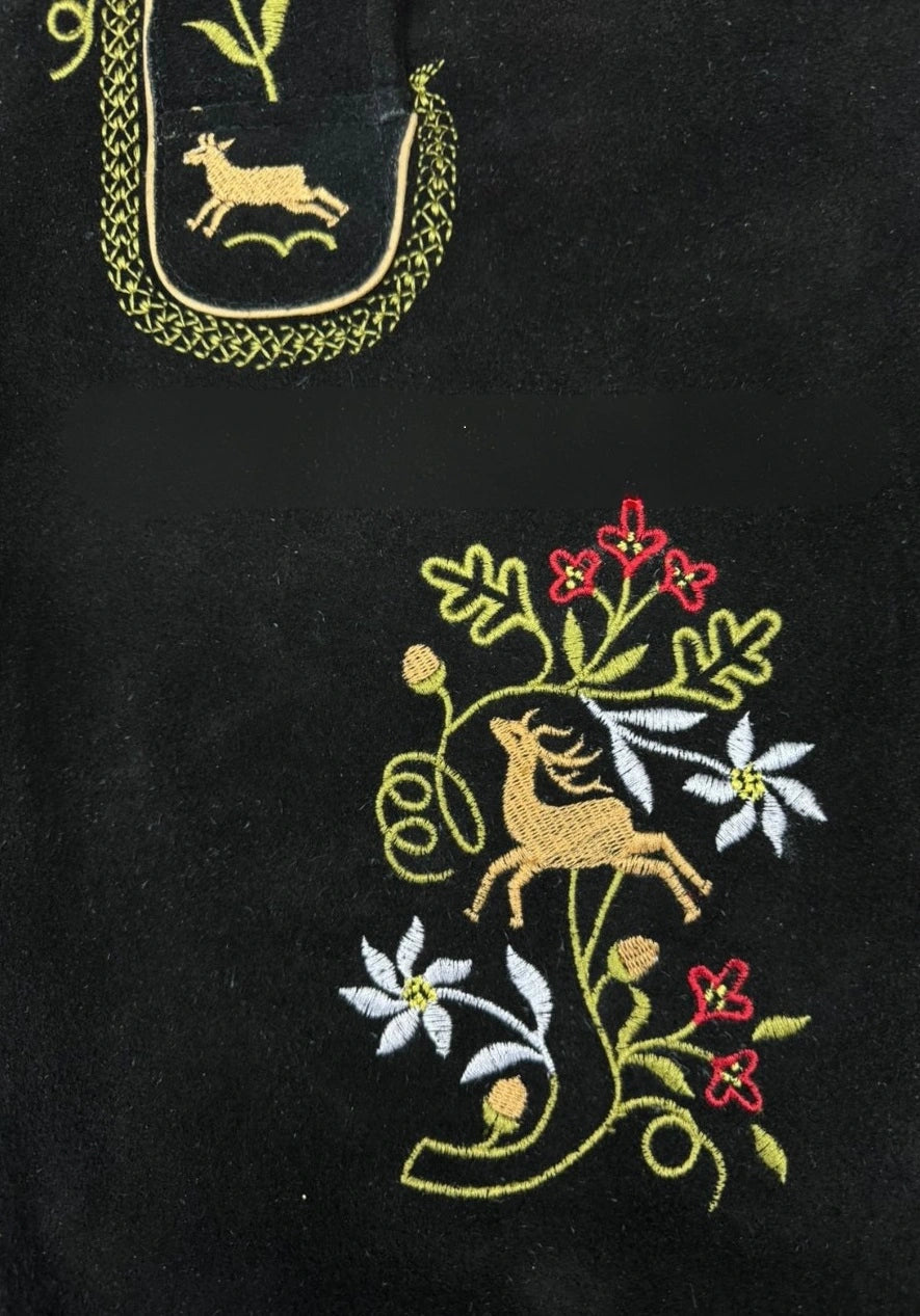 Embroidered design on a black fabric with deer and floral patterns.