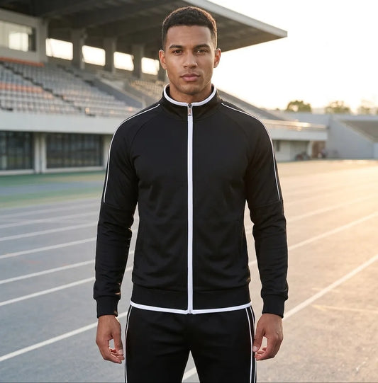 Man wearing a black tracksuit with white stripes on an outdoor track.