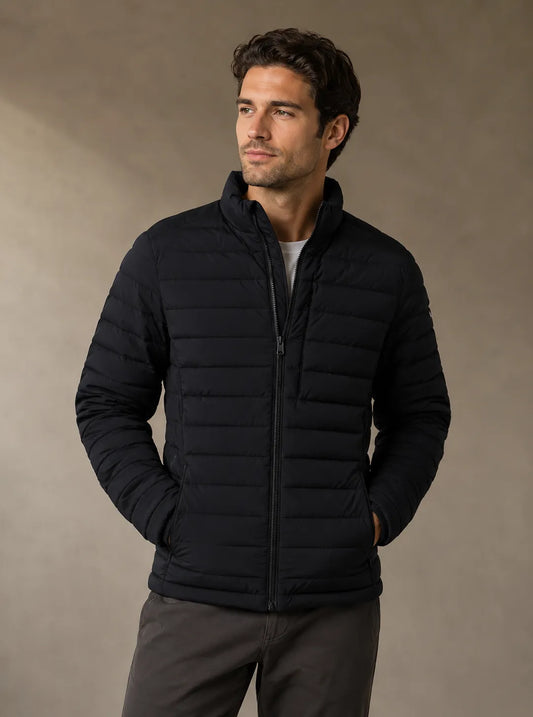 Man wearing a black puffer jacket against a beige background